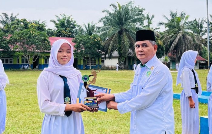 Kapten Voli Putri MTsN 5 Tebo Serahkan Trofi Juara I kepada Kepala Madrasah